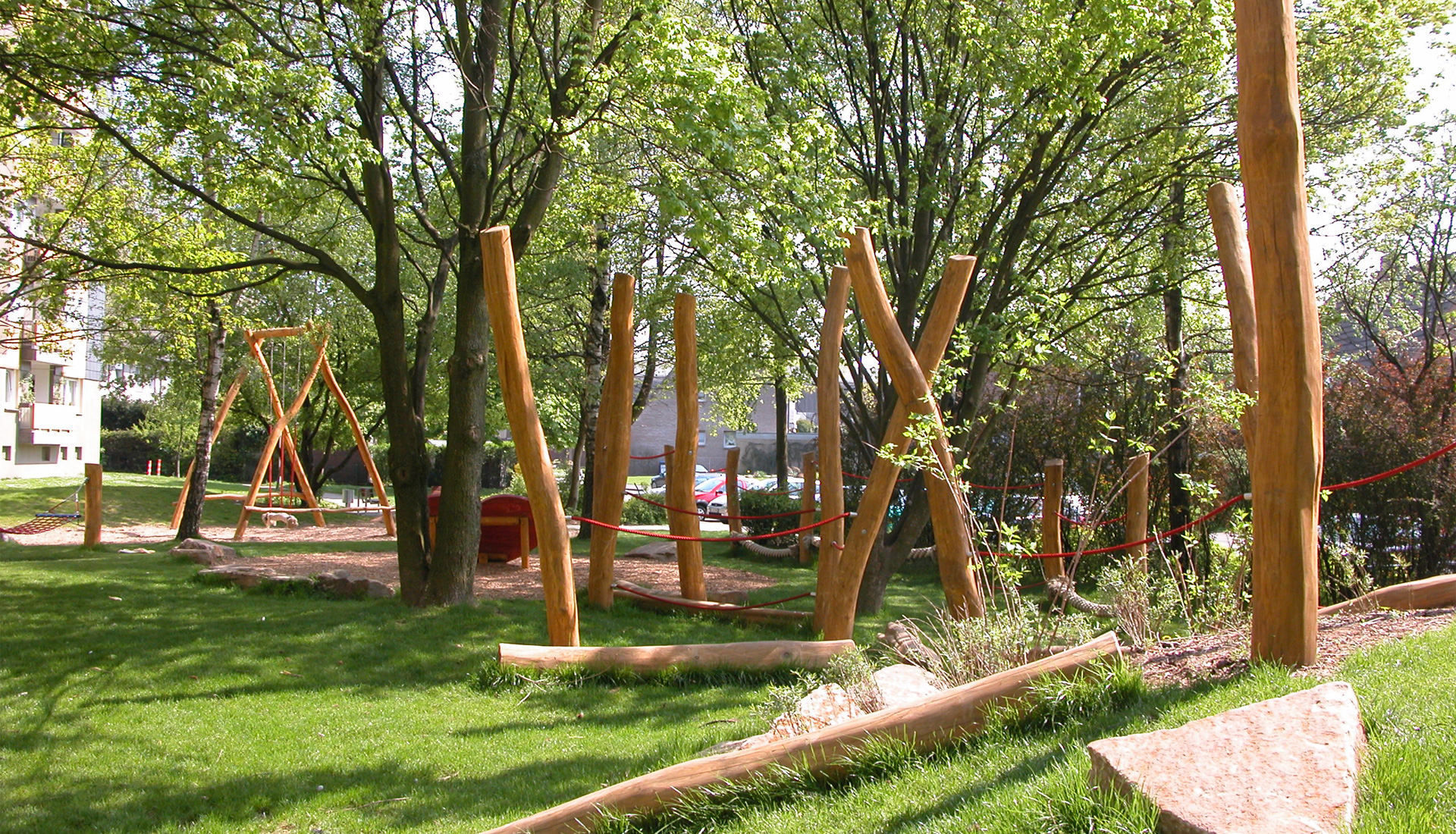 A play area with ropes strung between wooden posts.