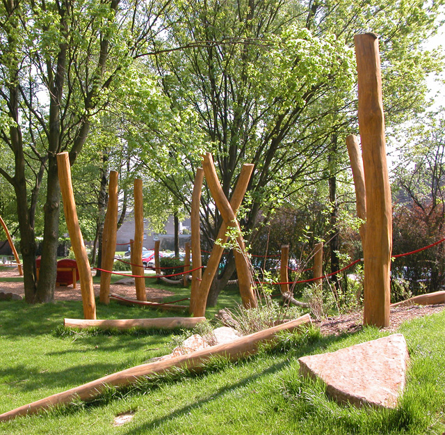 A play area with ropes strung between wooden posts.