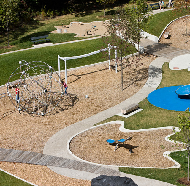 A childrens playground with swings, seesaws and a climbing frame.